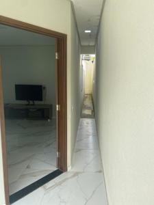 a hallway with a sliding glass door and a television at Bela Casa com 3 quartos mobiliada na Zona Leste in Teresina