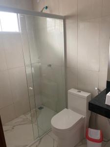 uma casa de banho com uma cabina de duche em vidro e um WC. em Bela Casa com 3 quartos mobiliada na Zona Leste em Teresina