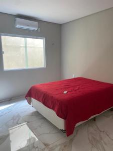 um quarto branco com uma cama com um cobertor vermelho em Bela Casa com 3 quartos mobiliada na Zona Leste em Teresina