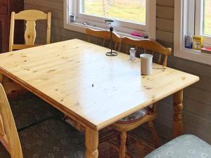 een houten tafel met 2 stoelen en een houten bij Holiday home Kokelv II in Kokelv