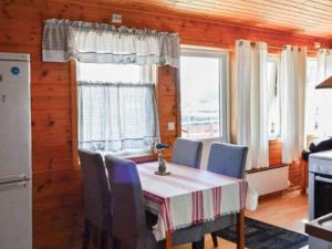 a dining room with a table and chairs and windows at 4 person holiday home in MÅLØY-By Traum in Måløy