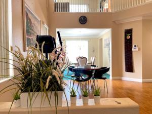 a living room with potted plants and a table at Homeinn - Luxe Residence Near Victoria Mall & Mills in Rancho Cucamonga