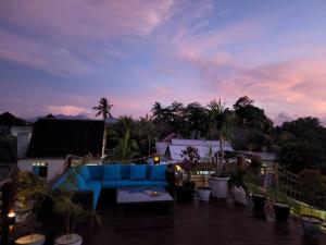 ギリ・アイルにあるRumah Tara Modern 3 bedroom pool and garden villa in Gili Airの青いソファ(パティオの上に座る)