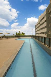 uma piscina de água azul ao lado de um edifício em BEACH CLASS INTERNATIONAL - Flat beira mar no Recife