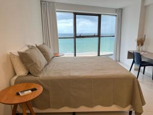 um quarto com uma cama grande e vista para o oceano em BEACH CLASS INTERNATIONAL - Flat beira mar no Recife