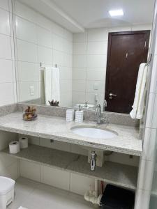 y baño con lavabo, espejo y aseo. en BEACH CLASS INTERNATIONAL - Flat beira mar, en Recife
