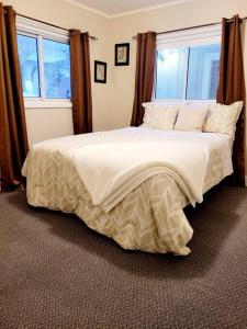 um quarto com uma grande cama branca e uma janela em Pines Bay Waterfront cottage with Hot tub! em Kawartha Lakes