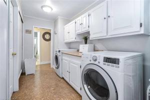 uma lavandaria branca com máquina de lavar e secar roupa em Pines Bay Waterfront cottage with Hot tub! em Kawartha Lakes