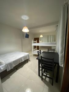1 dormitorio con 1 cama, mesa y sillas en Pousada Brunetti, en Penha
