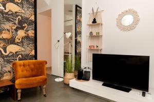 un soggiorno con TV e sedia di In Crowd Boho Apartment in Downtown a Zara (Zadar)