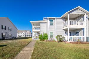 a large white house with a lawn in front of it at Cozy budget friendly condo close to the beach in Gulf Shores