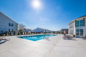 a swimming pool with chairs and a building at Cozy budget friendly condo close to the beach in Gulf Shores
