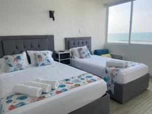 duas camas num quarto com o oceano ao fundo em FRAGATA STYLE 2 em Cartagena das Índias