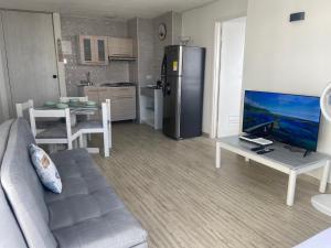 uma sala de estar com um sofá, uma televisão e uma cozinha em FRAGATA STYLE 2 em Cartagena das Índias