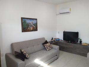 een woonkamer met een bank en een flatscreen-tv bij Casa Alebrijes in Tequila