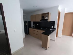 een keuken met een bureau en een zwarte koelkast bij Condominio OASIS 207 in San Jerónimo