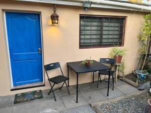 tavolo e sedie di fronte a una porta blu di Cabaña para 2 en ConCon a Concón