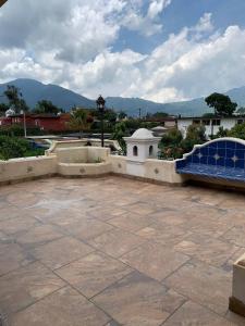 um pátio com um banco azul e montanhas ao fundo em Colonial Charm in Antigua - women only em Antigua Guatemala