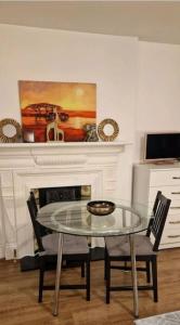 a dining room with a glass table and two chairs at Private spacious studio Ealing 2 mins from tube in London