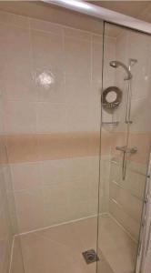 a shower with a glass door in a bathroom at Private spacious studio Ealing 2 mins from tube in London
