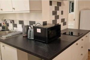 a microwave sitting on top of a kitchen counter at Private spacious studio Ealing 2 mins from tube in London