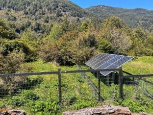 um painel solar no topo de uma colina com um campo em Refugio Macales em Puerto Dunn