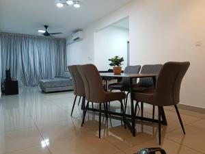 a dining table and chairs in a living room at Iman Homestay @ Puncak Alam (Near UiTM/Hospital UiTM) in Bandar Puncak Alam