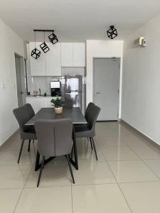 a dining room with a table and chairs in a kitchen at Iman Homestay @ Puncak Alam (Near UiTM/Hospital UiTM) in Bandar Puncak Alam