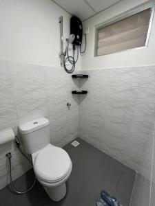 a small bathroom with a toilet and a window at Iman Homestay @ Puncak Alam (Near UiTM/Hospital UiTM) in Bandar Puncak Alam