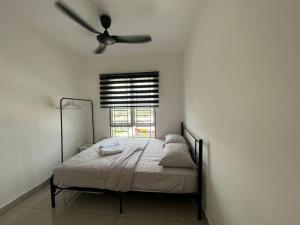 Iman Homestay @ Puncak Alam (Near UiTM/Hospital UiTM) في Bandar Puncak Alam: غرفة نوم مع سرير ومروحة سقف