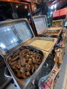 a buffet with several trays of food on a counter at Hotel Fazenda Bonanza in Engenheiro Paulo de Frontin