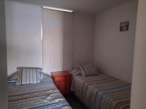 a room with two beds and a table in it at laguna del mar, la serena in La Serena