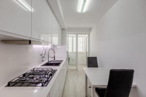 Spacious 3-bedroom condo in Lisbon في لشبونة: مطبخ ابيض مع موقد ومغسلة