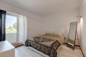Spacious 3-bedroom condo in Lisbon في لشبونة: غرفة نوم بها مرآة وسرير ونافذة