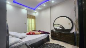 شقة فندقية مكيفة ميامي ع البحر مباشرةً في الإسكندرية: غرفة نوم مع مرآة كبيرة وسرير