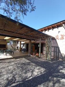 a patio of a house with a wooden pergola at LA AGÜITA PERDIDA in Raco