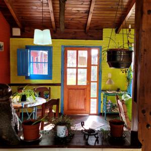 Zimmer mit einer Tür und einem Tisch mit Pflanzen in der Unterkunft Lago Argentino Hostel in El Calafate