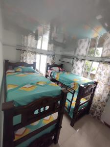 Dos camas individuales en una habitación con ventana. en Apartamentos Familiares The Upper room 202, en San Andrés