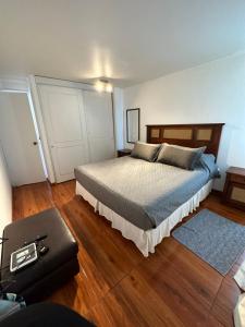 a bedroom with a large bed and wooden floors at Linda Vista in Iquique