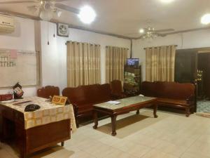ein Wohnzimmer mit Sofas und einem Tisch in der Unterkunft Nocknoy Lanexang Guest House in Luang Prabang