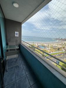 a room with a view of the beach from a window at Linda Vista in Iquique