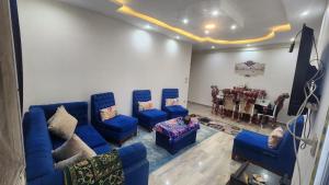 a living room with blue couches and a table at شقة فندقية مكيفة ميامي ع البحر مباشرةً in Alexandria