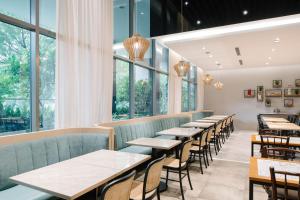 a row of tables in a restaurant with windows at Hotel Traveltine in Singapore