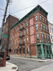 um edifício de tijolos numa esquina com uma placa de rua em The Reserve - Heart of OTR 2 Bed Suite w/Views em Cincinnati