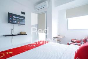 RedLiving Apartemen Gunung Putri Square - Sansan Room with Netlfix في Parungtandjung: غرفة نوم مع سرير وتلفزيون على الحائط