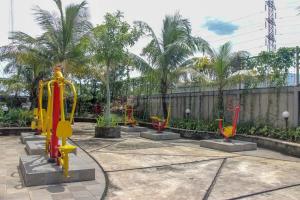 um parque infantil com equipamento amarelo e vermelho num parque em RedLiving Apartemen Gunung Putri Square - Sansan Room with Netlfix em Parungtandjung