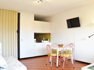 uma cozinha com mesa e cadeiras num quarto em Appartement Le Lavandou, 1 pièce, 4 personnes - FR-1-251-187 em Le Lavandou
