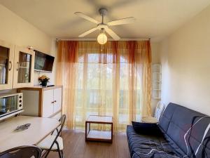 a living room with a blue couch and a table at Studio RDC proche centre et thermes avec Wifi - FR-1-451-76 in Lamalou-les-Bains