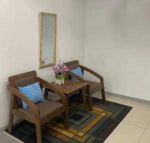 a table and chairs with a vase of flowers on a rug at Klia Redza Homestay Kota Warisan Malay only in Sepang