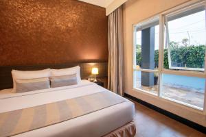 Una cama o camas en una habitación de Solaris Hotel Malang